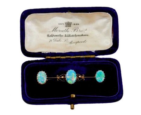 Edwardian opal bar brooch with three opal cabochons on 15ct gold knife bar with scrolls, 49mm