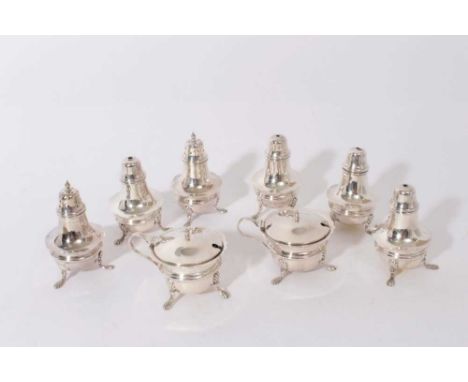George V silver cruet set of cauldron form, raised on three splayed paw feet, comprising two mustard pots, two pepperettes an