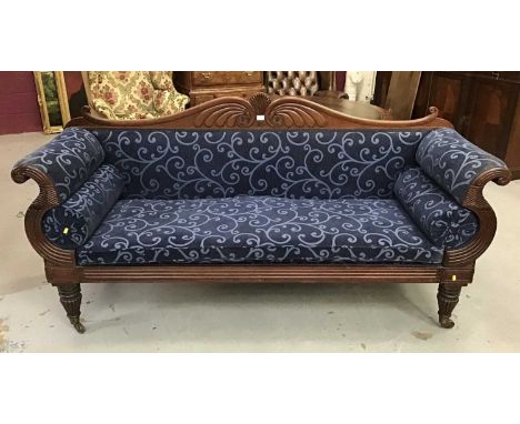 Regency mahogany sofa with carved frame and double scroll ends, blue upholstery on tapered fluted legs terminating on brass c