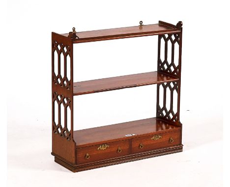 A GEORGE III STYLE HANGING THREE TIER WALL SHELFWith fret cut sides and a pair of drawers, 63cm wide; 66cm high