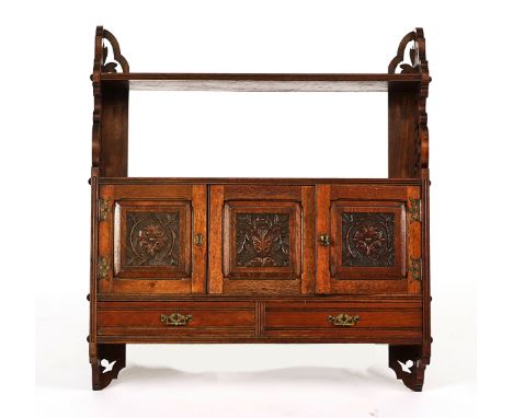 AN AESTHETIC MOVEMENT WALNUT HANGING SHELFWith a trio of carved panels over drawers, 69cm wide; 76cm highCondition report:&nb