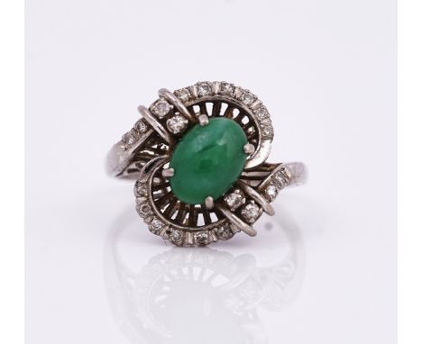 A white gold, jade and diamond ringClaw set with an oval cabochon jade, otherwise mounted with circular cut diamonds, in a tw