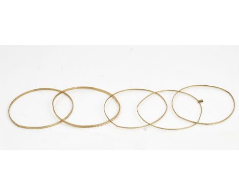 A 9ct gold bangle and four further bangles (5)The 9ct gold bangle with facet cut decoration, weight 4.8 gms and four further 