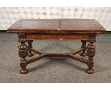 A 17TH CENTURY STYLE OAK DRAW-LEAF REFECTORY TABLEThe cleated top above inlaid frieze, with carved foliate bulbous legs, join