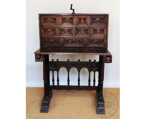 A 17th century style Spanish carved walnut vargueno on stand, 19th century, the front carved with a mythological scene of god