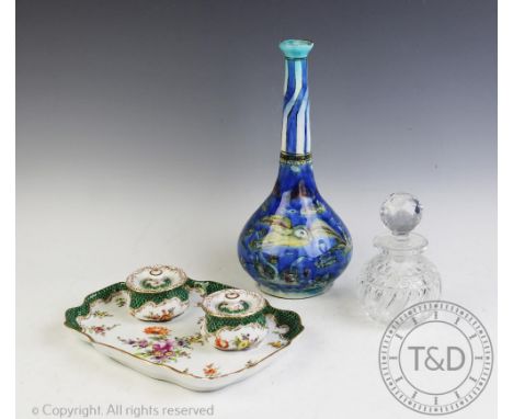 A Dresden porcelain desk stand, with two ink wells and covers and shaped tray, decorated with flowers under a green fish scal