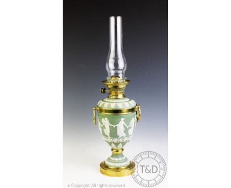 A late 19th century Wedgwood green jasper ware oil lamp, the urn shaped base brass mounted and decorated with a 'Dancing Hour