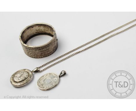 A Victorian style silver hinged bangle with anthemion and floral detail, stamped 'Stg Silver', along with two oval lockets ea