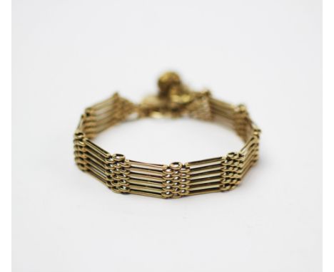A 9ct gold 'gate' type bracelet, designed as six 'bar' articulated panels, with attached padlock clasp and additional Victori