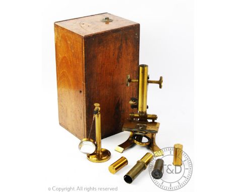 A late Victorian lacquered brass microscope, within a fitted mahogany case, with associated slides, magnifying stand, lenses 
