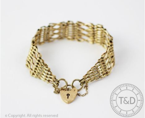 A 9ct yellow gold 'gate' style bracelet, designed as alternating panels of X shaped links and ladder panels, tapering to a he