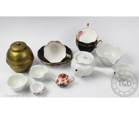 A Korean porcelain tea service, 20th century, comprising; a side pouring teapot, three tea bowls and wooden stands and pourin