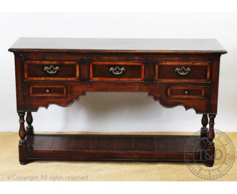 A George III style oak dresser, with an arrangement of five drawers, above a pot shelf, on turned legs, 75cm H x 129cm W x 38