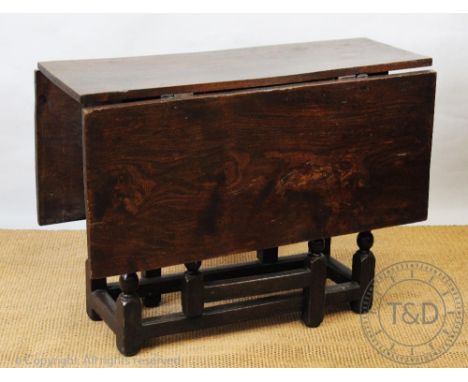 An 18th century and later elm and oak drop leaf dining table, on bobbin legs, 74cm H x 100cm W