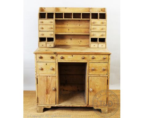 A pine butlers / clerks desk, the upper section with an arrangement of twelve alcoves and ten drawers, on base with five draw