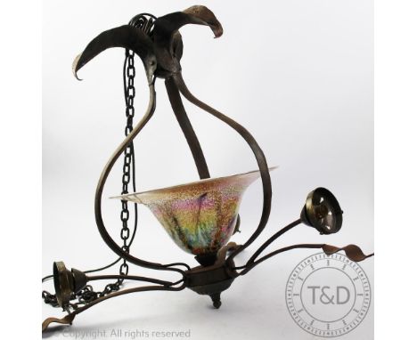 An Arts and Crafts style wrought iron ceiling light, of foliate form, hung with a central mottled glass shade and three arms,