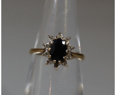 A 9ct gold oval sapphire and diamond cluster ring.  Ring size I.  Approx weight 1.7g. (B.P. 21% + VAT) 