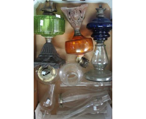 Box containing 3 oil lamps with coloured glass reservoirs and a 4th small clear glass oil lamp and 6 clear glass chimneys.  1