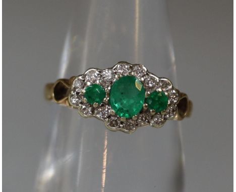 A three stone emerald and diamond ring set in 9ct gold.  Ring size K&amp;1/2.  Approx weight 2.4 grams. (B.P. 21% + VAT) 