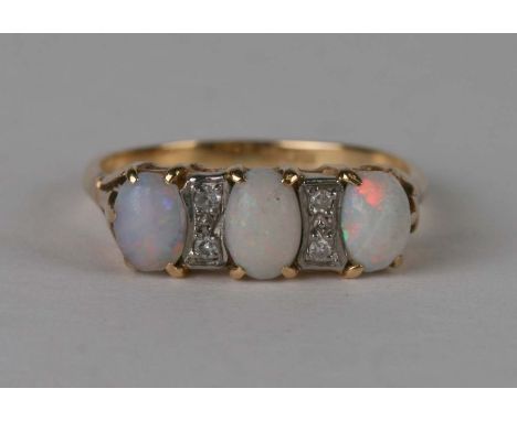 An 18ct gold opal and diamond ring with three oval opal cabochons interspersed with four diamonds, approx UK size 'O', 3.1g.C