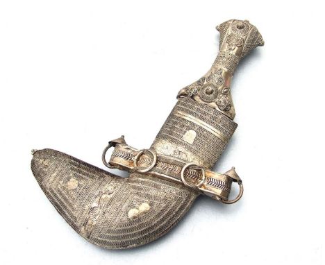 A Middle Eastern Jambiya dagger with white metal handle and scabbard, blade length 15cms, overall 27cms.