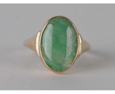 A yellow metal (test as 18ct) ring set with an oval jade cabochon, approx UK size 'T', 5.6g.