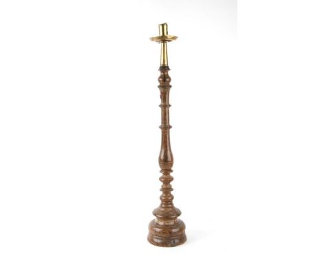 A large turned wooden candlestick with brass sconce (possibly 17th century), 60cms high.