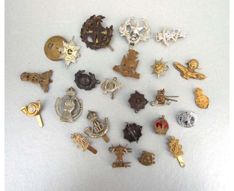 An assortment of twenty three early to mid 20th century British Military badges including Royal Armoured Corps, Durham Light 
