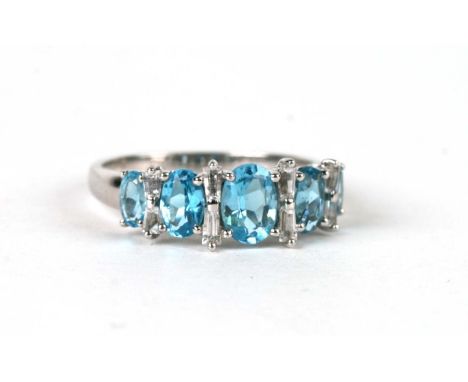 A 9ct white gold dress ring set with five pale blue stones interspersed with baguette cut white stones, approx UK size 'R', 4