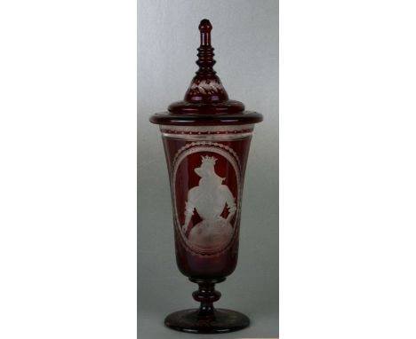 A Bohemian ruby flashed goblet and cover with engraved decoration depicting figures in an interior, approx 37cms high.Conditi