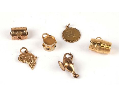 Four 9ct gold charms to include a treasure chest and Aladdin's lamp; together with two 18ct gold charms in the form of a barr
