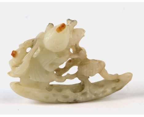 A Chinese mutton fat jade carving depicting a boy tending a tree, 7cms wide.
