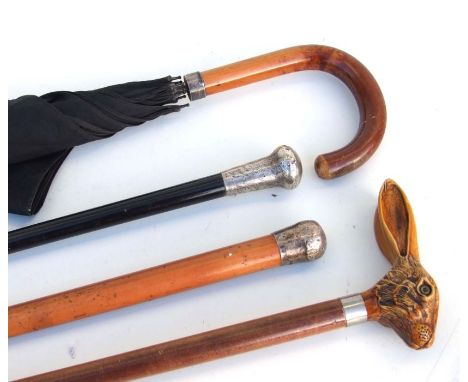 Two silver topped walking canes; together with a silver mounted umbrella; and a modern mahogany walking stick with hare's hea