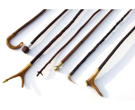 An antler handled walking stick; together with similar walking sticks.