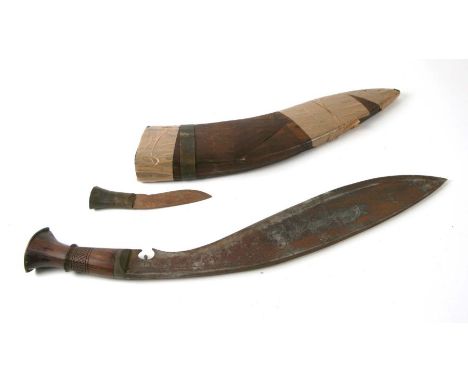 A large kukri in a carved wooden scabbard, 55cms long.