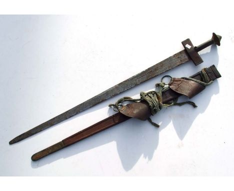 A Sudanese Islamic Kaskara sword in a tooled brass mounted leather scabbard with shoulder straps, overall 96cms long.