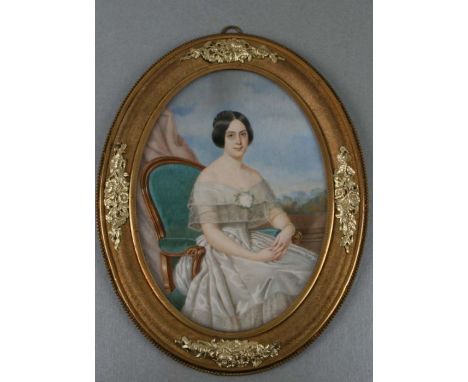 A 19th century oval bust portrait miniature depicting a lady seated in an armchair wearing a silk dress, watercolour on vellu