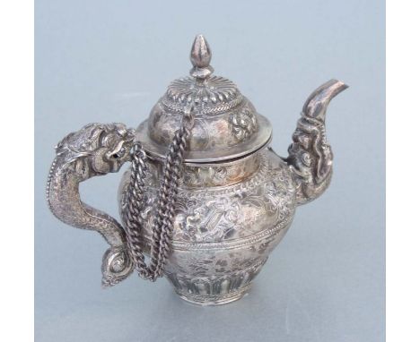 A Tibetan silver teapot with stylised mythical beast spout and dragon handle, 11cms high, weight 220g.