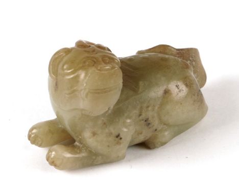 A Chinese russet jade carving in the form of a recumbent lion, 6cms long.