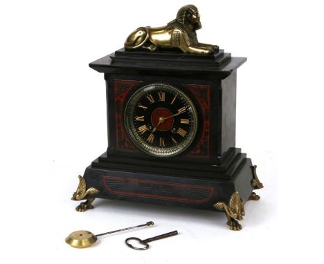 A Victorian Egyptian Revival black slate and marble mantle clock, the black dial with Roman numerals, the case surmounted wit