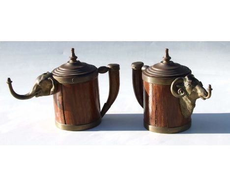 A pair of 19th century Prussian brass mounted oak welcome jugs with elephant and ram masks, incorporating an oil lamp cigar l