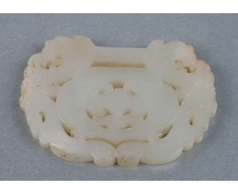 A Chinese carved jade buckle, the carved decoration depicting dragons and bats.