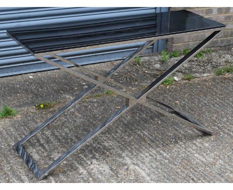 A modern chrome X-framed console table with black glass top, 120 x 40cm.