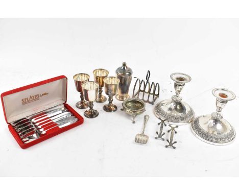 A small quantity of silver plated items including pair of candlesticks, three goblets, toast rack, etc.