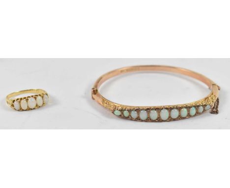 A 9ct gold bangle set with eleven opals, approx 7.2g, also a yellow metal five stone opal ring, approx 2.6g.