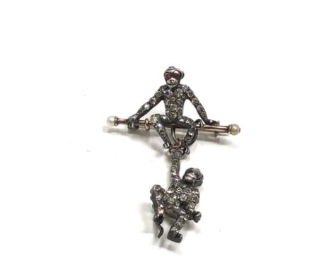 An Art Deco German sterling silver brooch by Knoll&amp;  Pregizer, modelled as a monkey sat on a bar, with pearls to either e