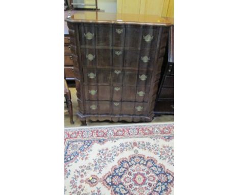 A Louis XV style walnut serpentine fronted commode of five long drawers raised on shaped supports