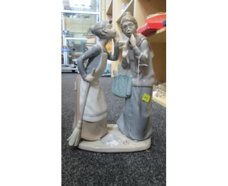 A Lladro porcelain figure group, modelled as a maid with broom, whispering to an elderly lady carrying basket of shopping