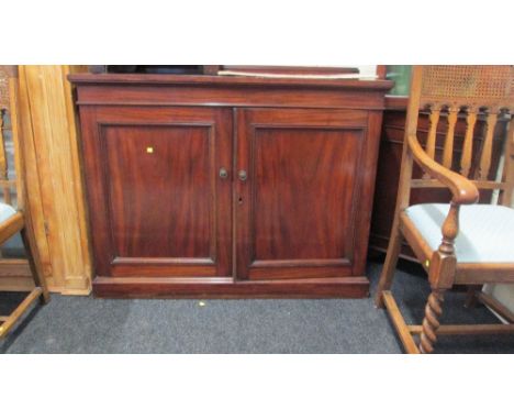 A 19th century mahogany cupboard, having low upstand over a rectangular top and pair of panelled cupboard doors, enclosing sh