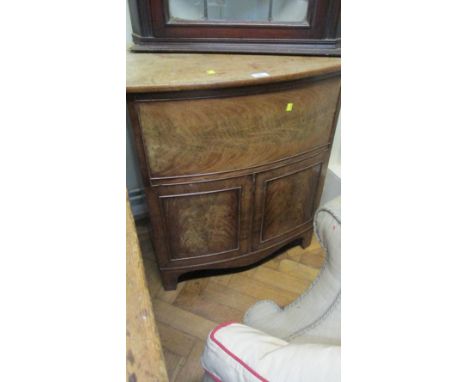 A George IV flame grain mahogany bowfront commode cabinet with splay supports